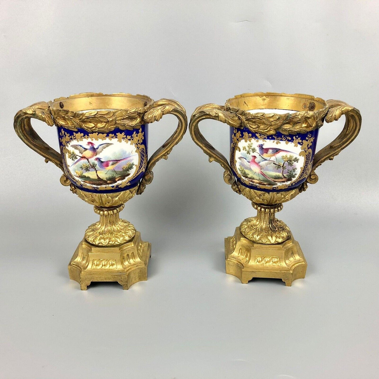 A pair of ormolu Sèvres-style vases painted with exotic birds and putti 1770