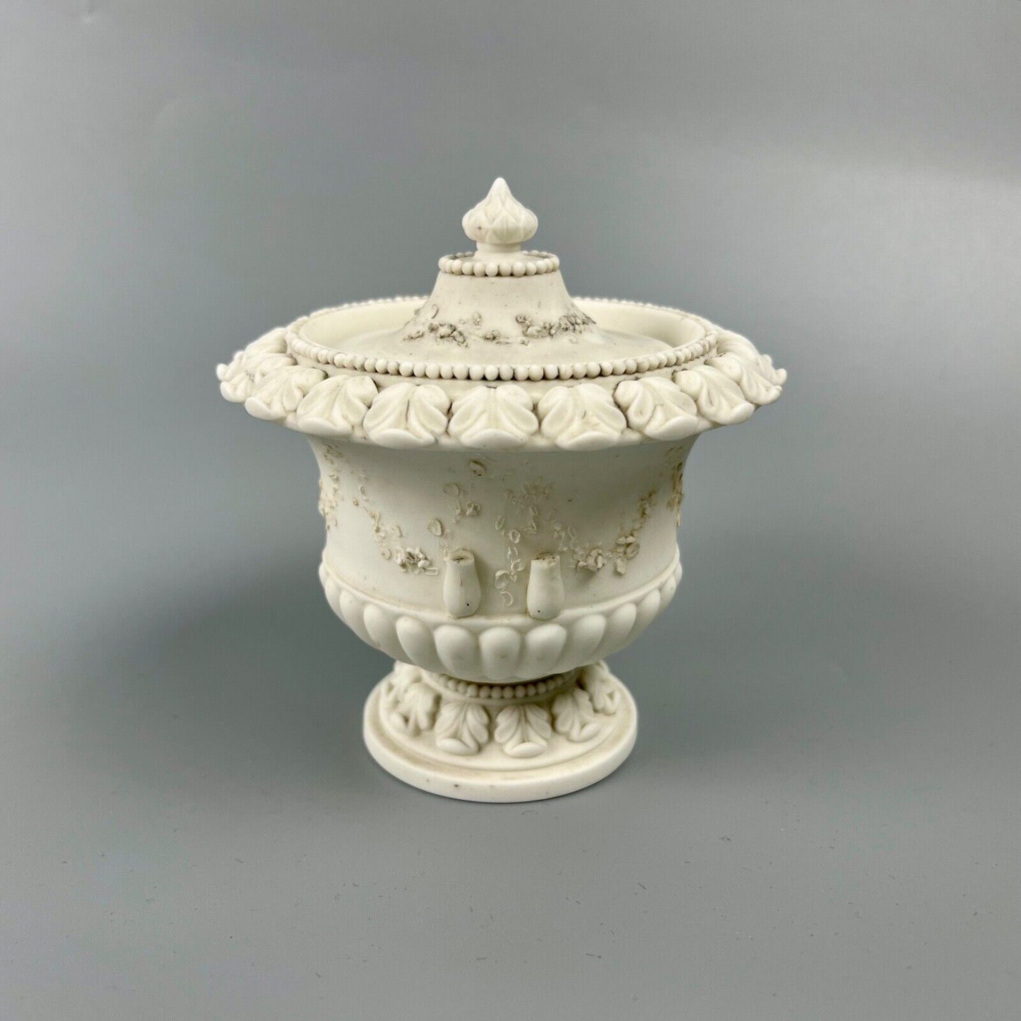 A rare Swansea biscuit lidded urn modelled with flowers and acanthus. c1814-17