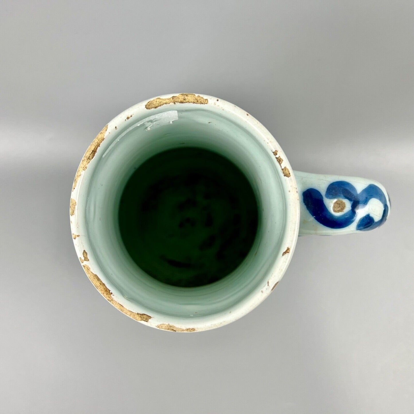 An early 18thc Dutch Delft jug painted with peacocks, holey rocks and peonies