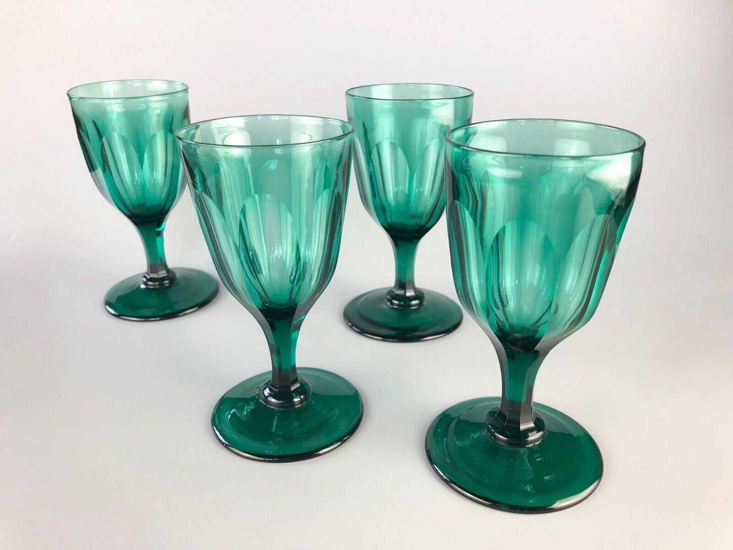 A set of four early Victorian (c1840) green glass slice-cut wine glasses
