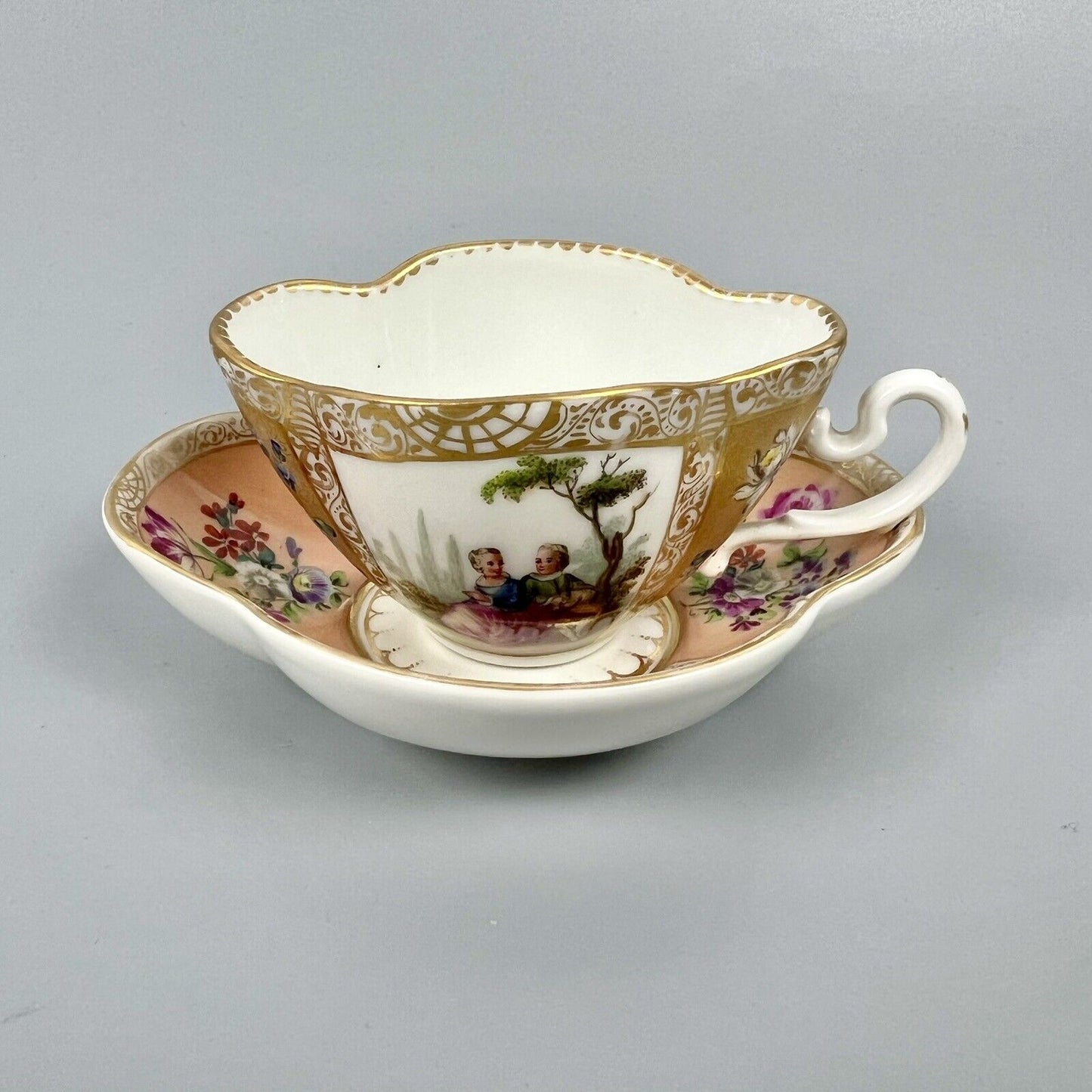 Dresden quatrefoil teacup & saucer painted with romantic scenes. 'AR' mark c1880