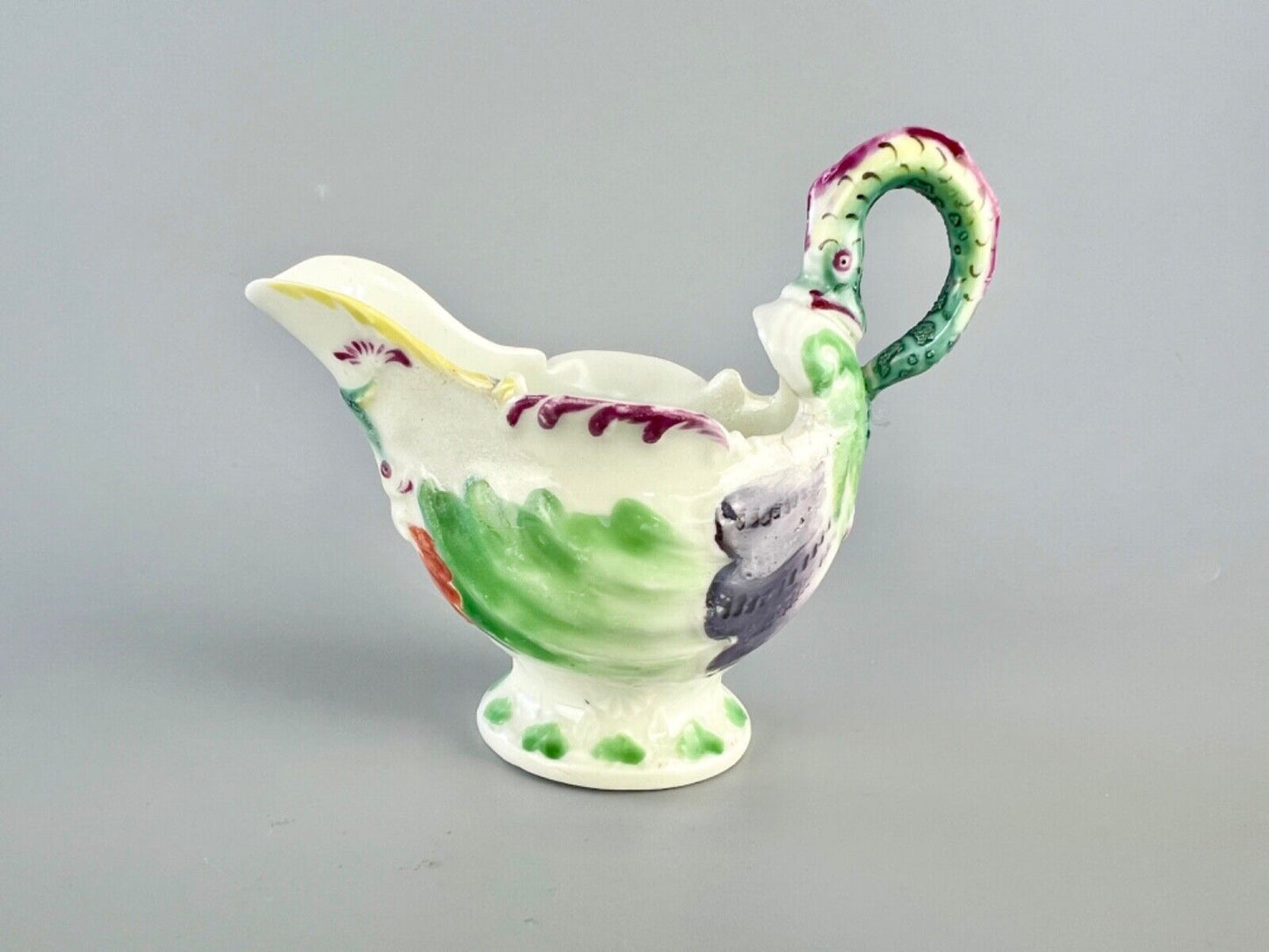 A c.1765 Worcester lamprey-handled dolphin-ewer creamer. Polychrome decoration.