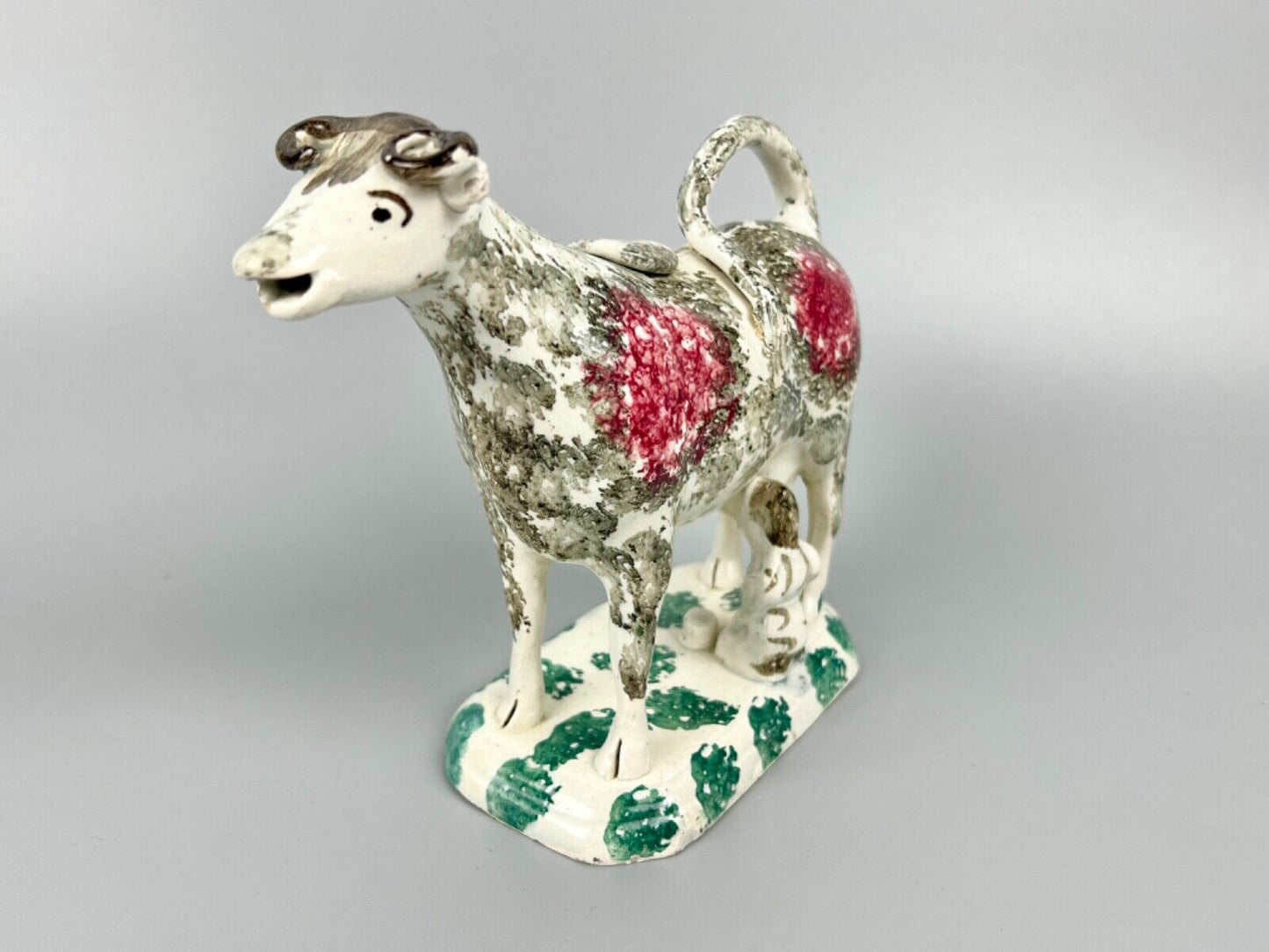 A c.1820 pottery cow and milkmaid creamer in crimson and black. Poss. Yorkshire