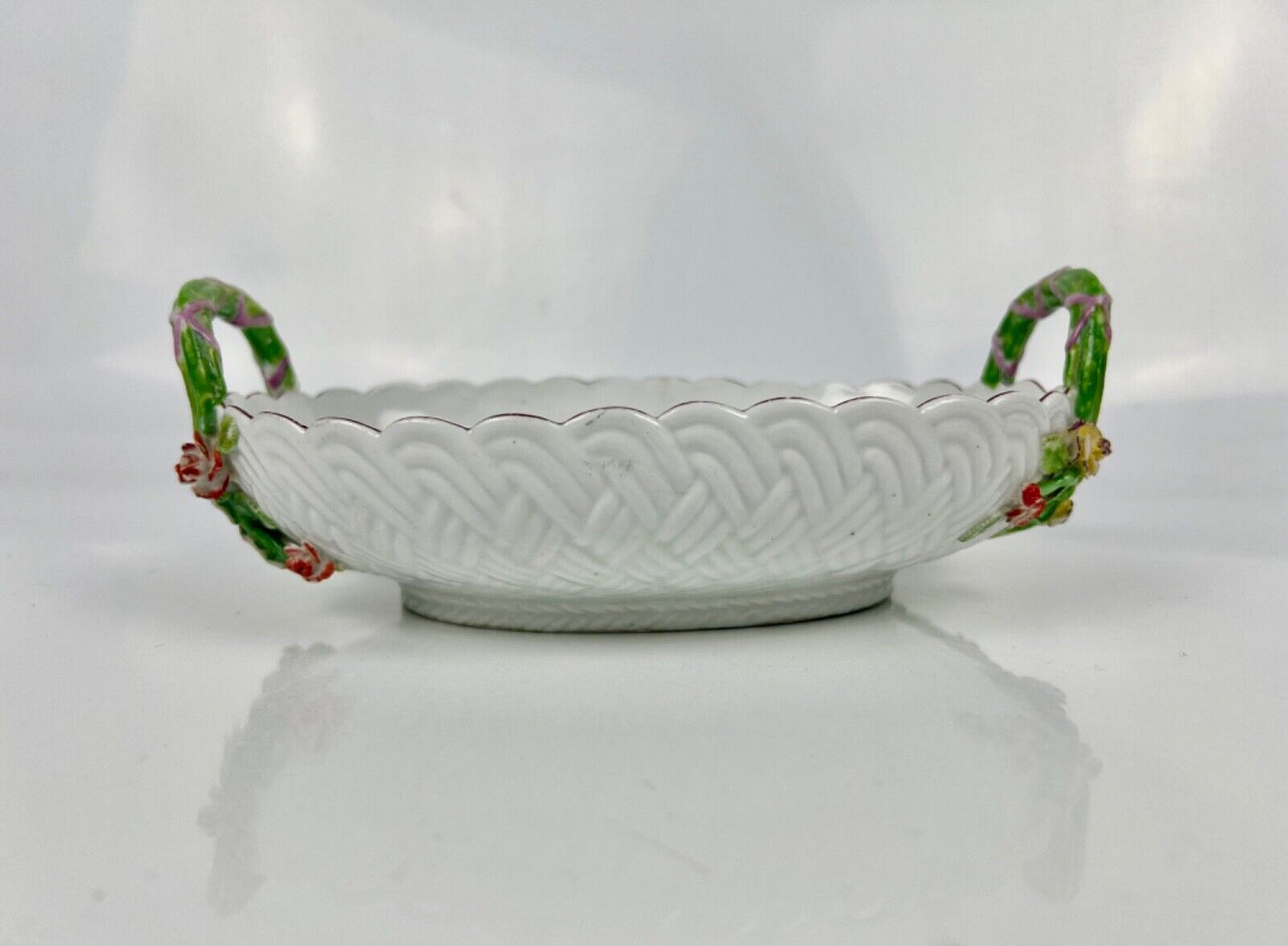 A good Chelsea basketweave moulded basket painted with bouquets. Rustic handles