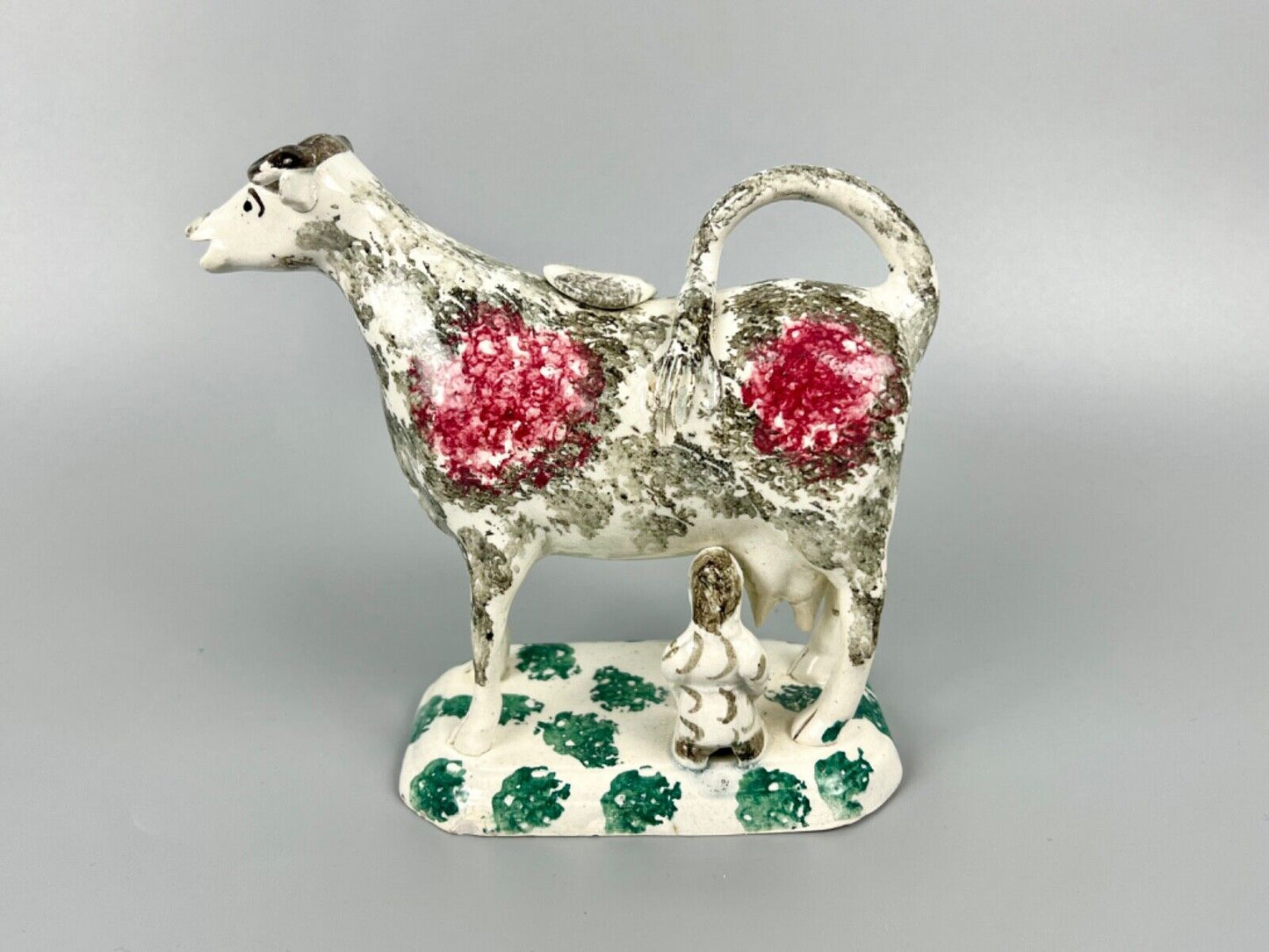 A c.1820 pottery cow and milkmaid creamer in crimson and black. Poss. Yorkshire