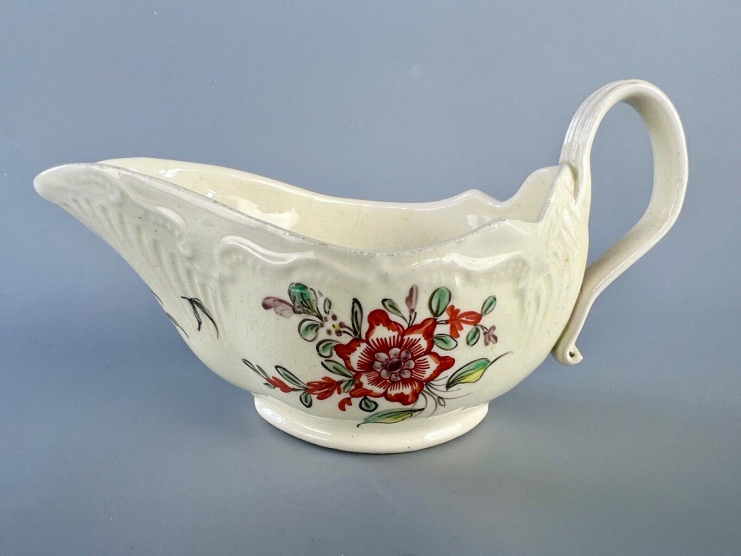 A c1775 creamware sauceboat painted with floral sprays. Probably Staffordshire.