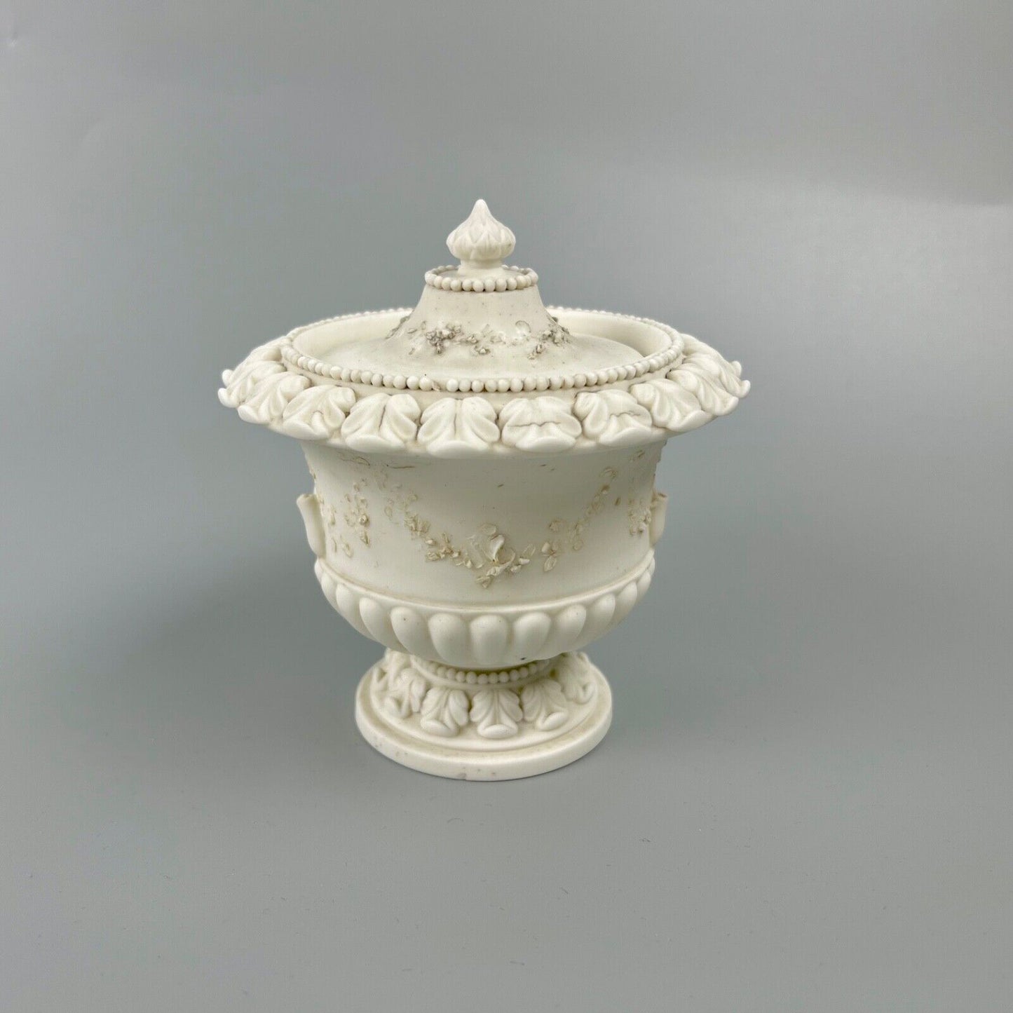 A rare Swansea biscuit lidded urn modelled with flowers and acanthus. c1814-17