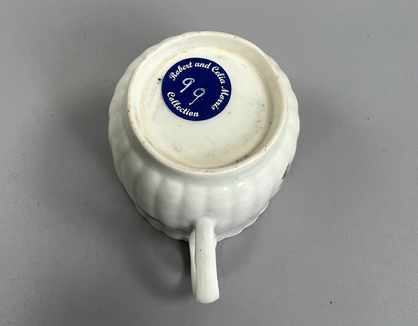 A Worcester reeded French shape coffee cup, painted with flowers and a ladybird
