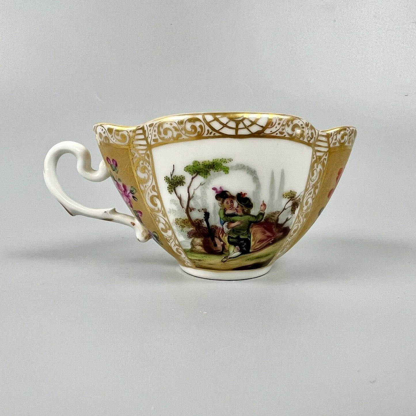 Dresden quatrefoil teacup & saucer painted with romantic scenes. 'AR' mark c1880