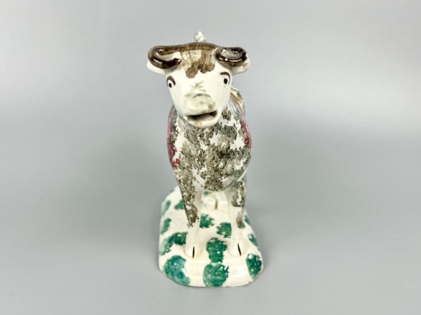 A c.1820 pottery cow and milkmaid creamer in crimson and black. Poss. Yorkshire