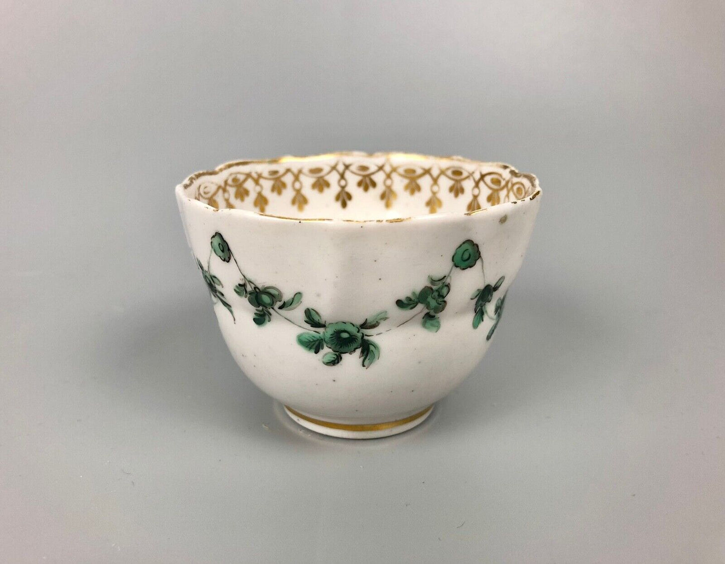 A Derby tea bowl and saucer in the style of Bristol c.1775
