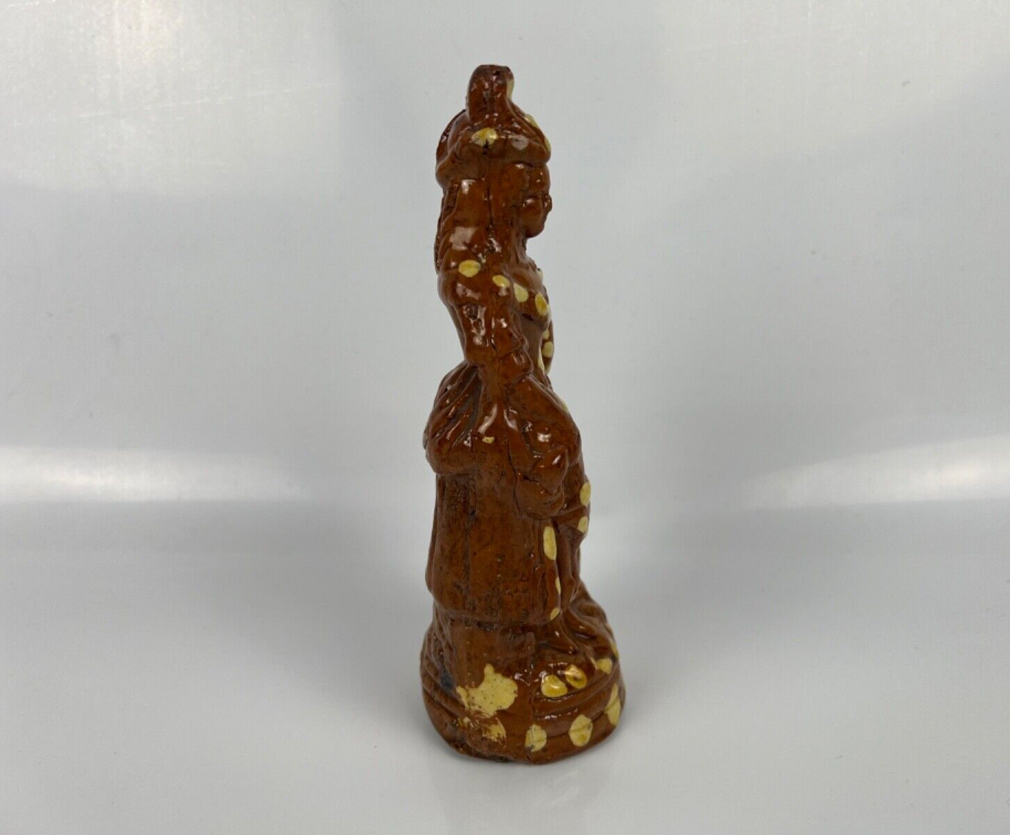 A cream dot decorated slipware figure of a woman on a treacle ground c1835