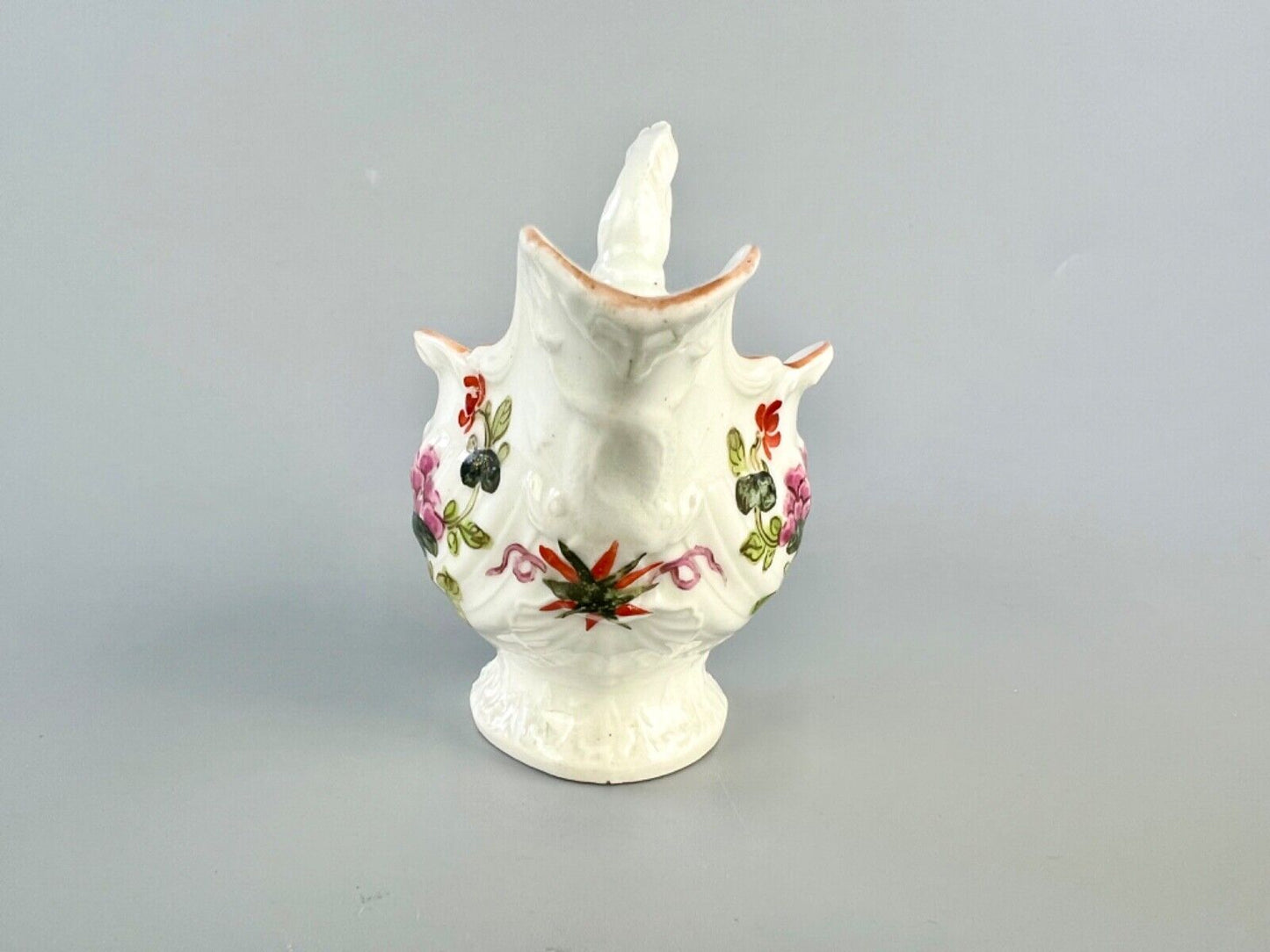 A c.1765 Worcester lamprey-handled dolphin ewer cream jug painted with flowers.