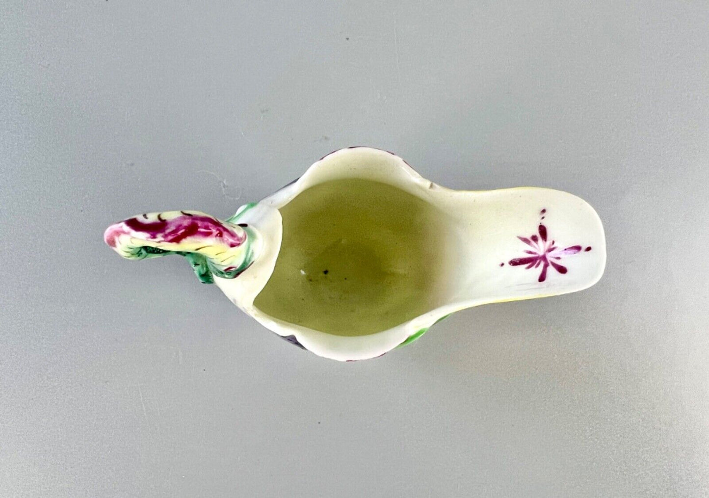 A c.1765 Worcester lamprey-handled dolphin-ewer creamer. Polychrome decoration.