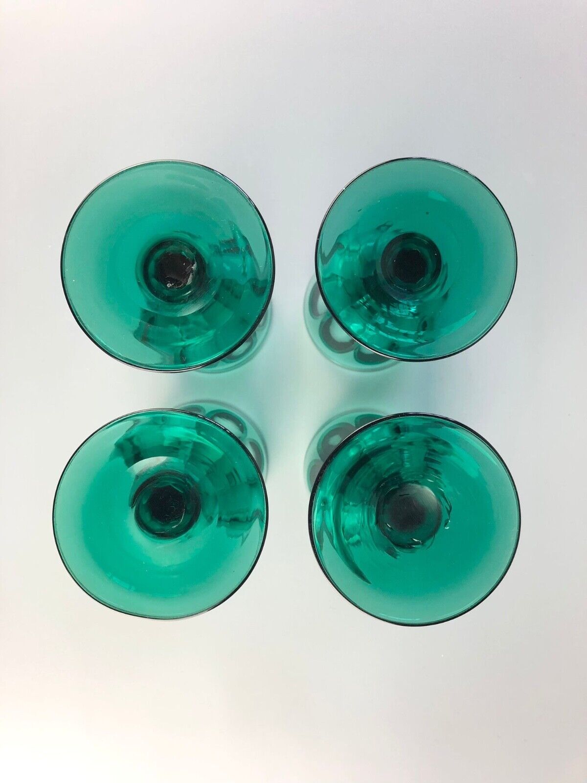 A set of four early Victorian (c1840) green glass slice-cut wine glasses