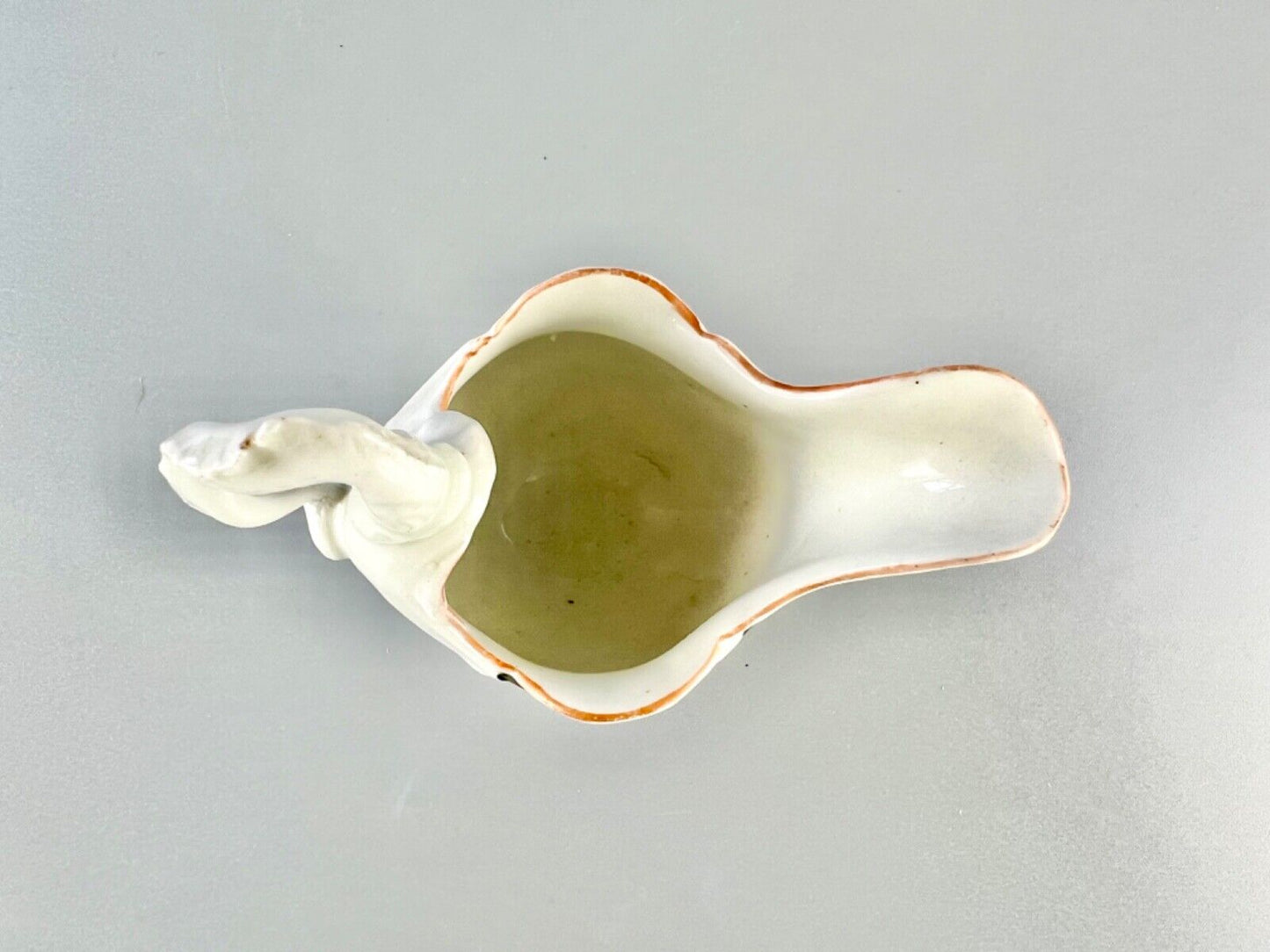 A c.1765 Worcester lamprey-handled dolphin ewer cream jug painted with flowers.