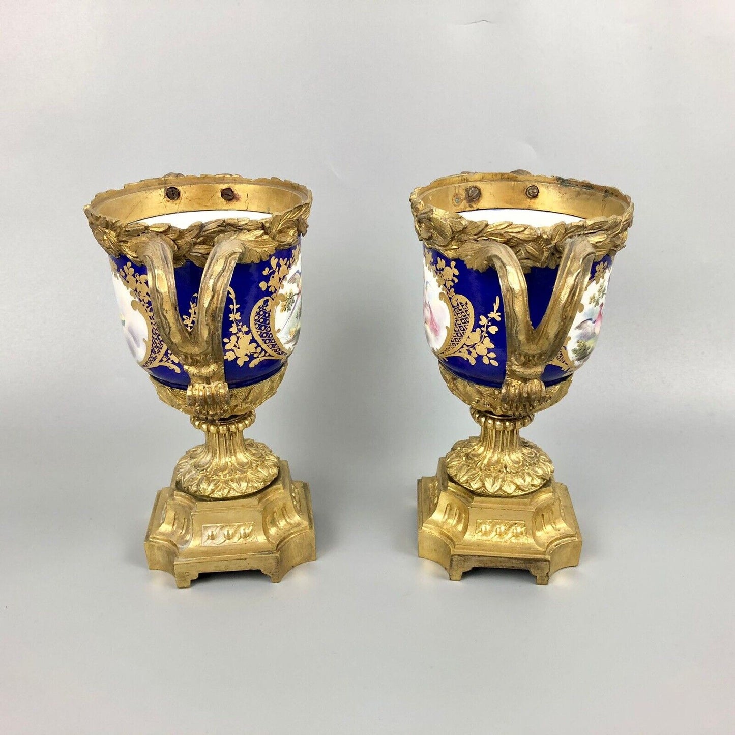 A pair of ormolu Sèvres-style vases painted with exotic birds and putti 1770