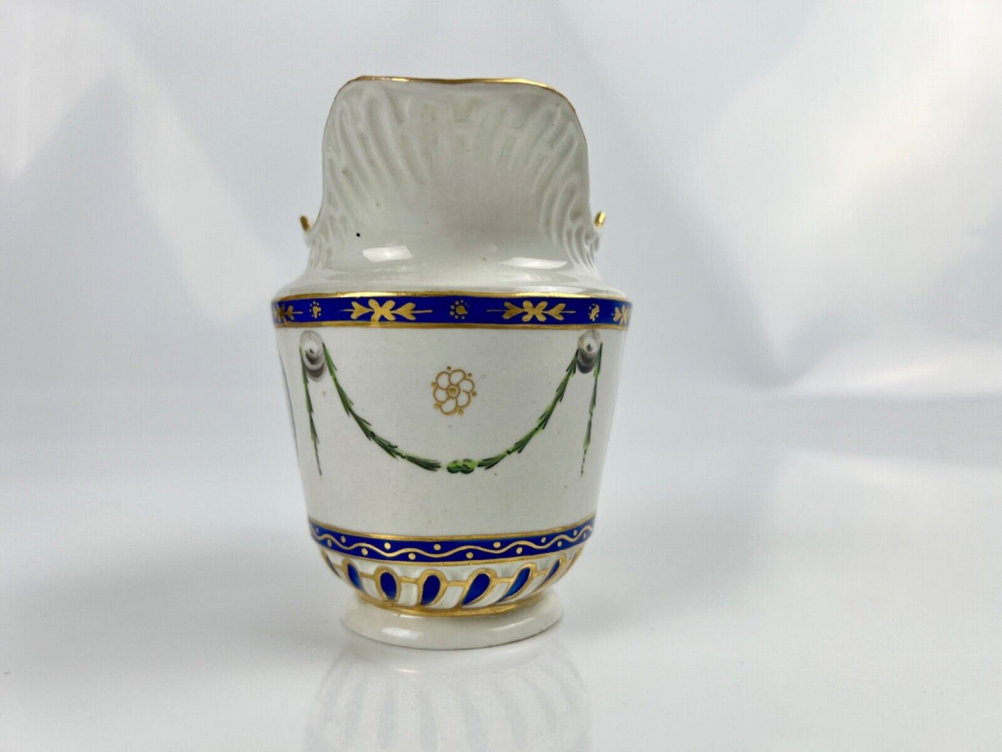 A Chelsea-Derby cabaret creamer of empire shape painted with mask heads c.1770