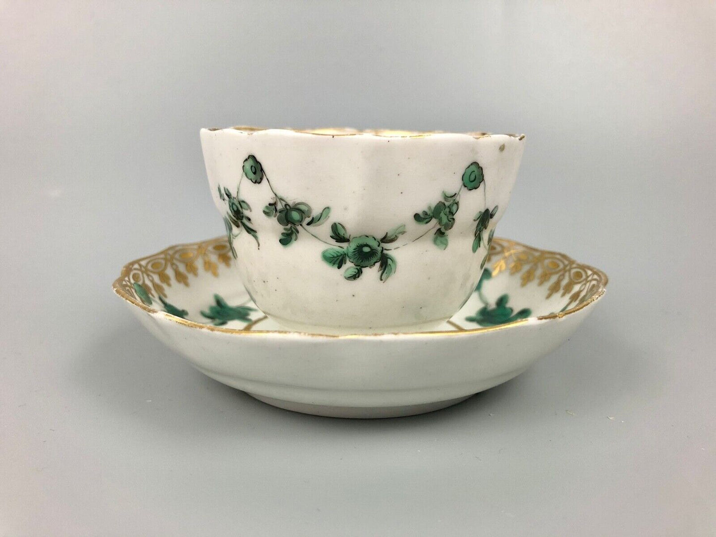 A Derby tea bowl and saucer in the style of Bristol c.1775