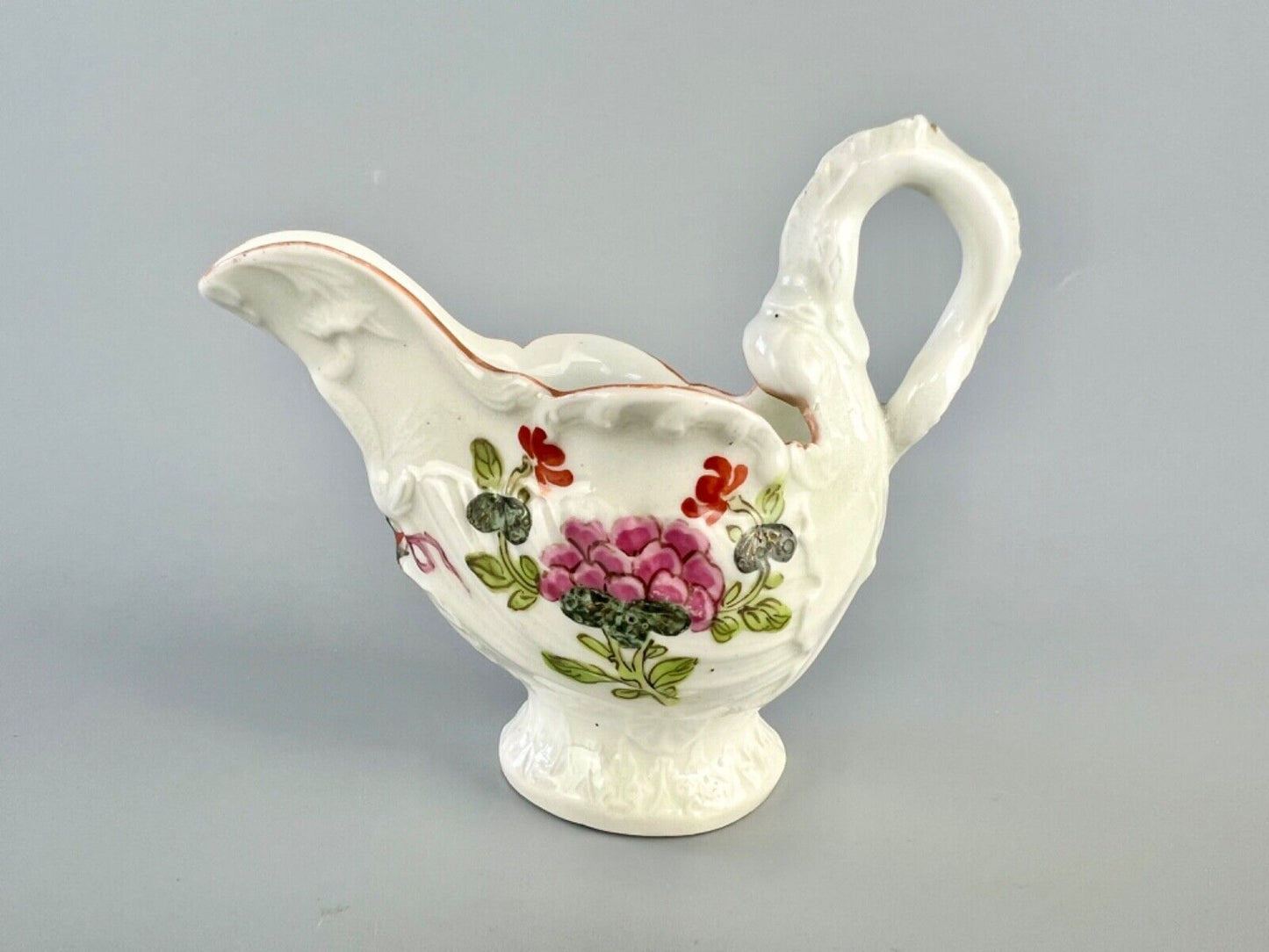 A c.1765 Worcester lamprey-handled dolphin ewer cream jug painted with flowers.