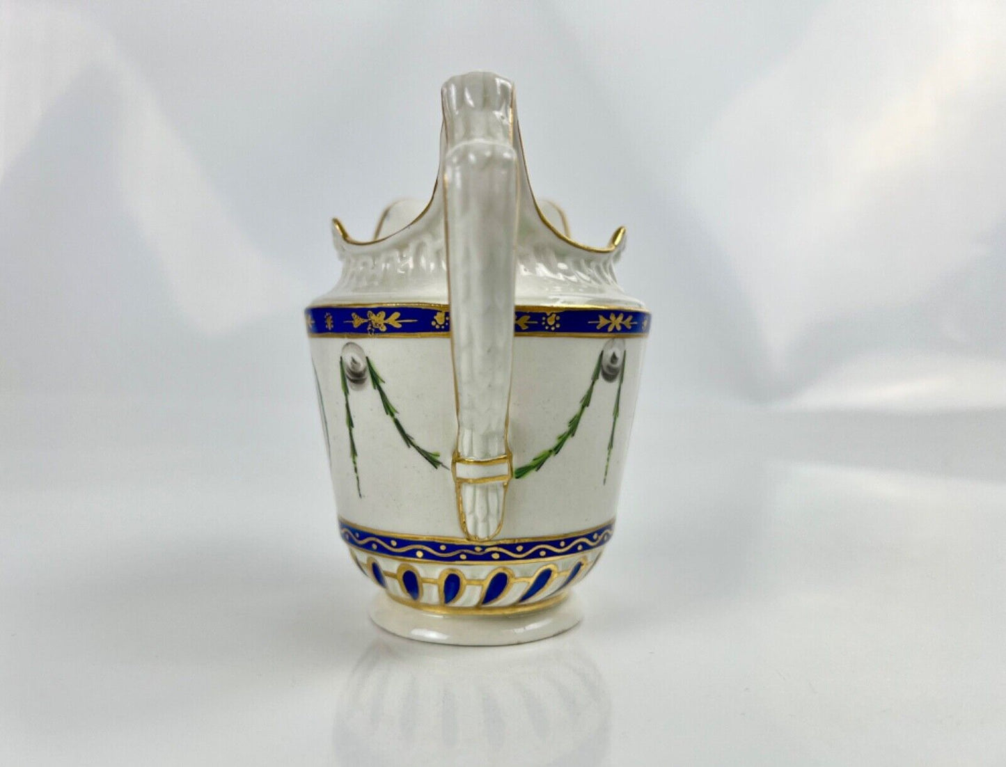 A Chelsea-Derby cabaret creamer of empire shape painted with mask heads c.1770