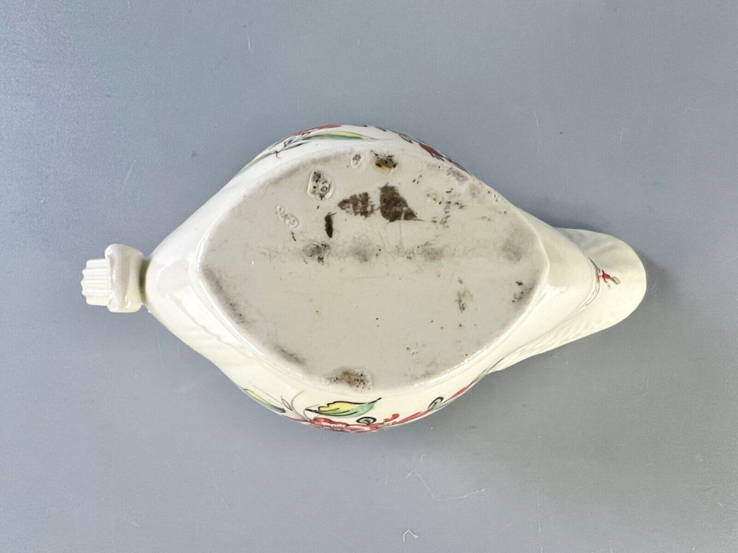 A c1775 creamware sauceboat painted with floral sprays. Probably Staffordshire.