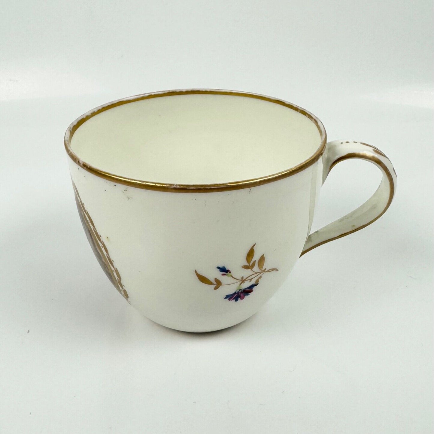A Pinxton cup and saucer in pattern 174 with painted scenes by Billingsley c1810