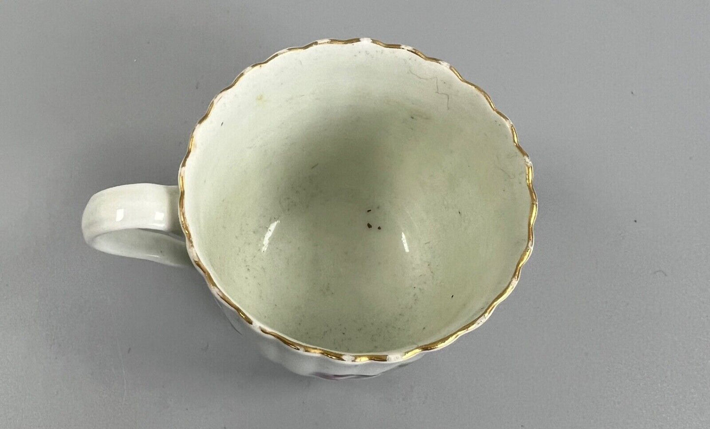 A Worcester reeded French shape coffee cup, painted with flowers and a ladybird