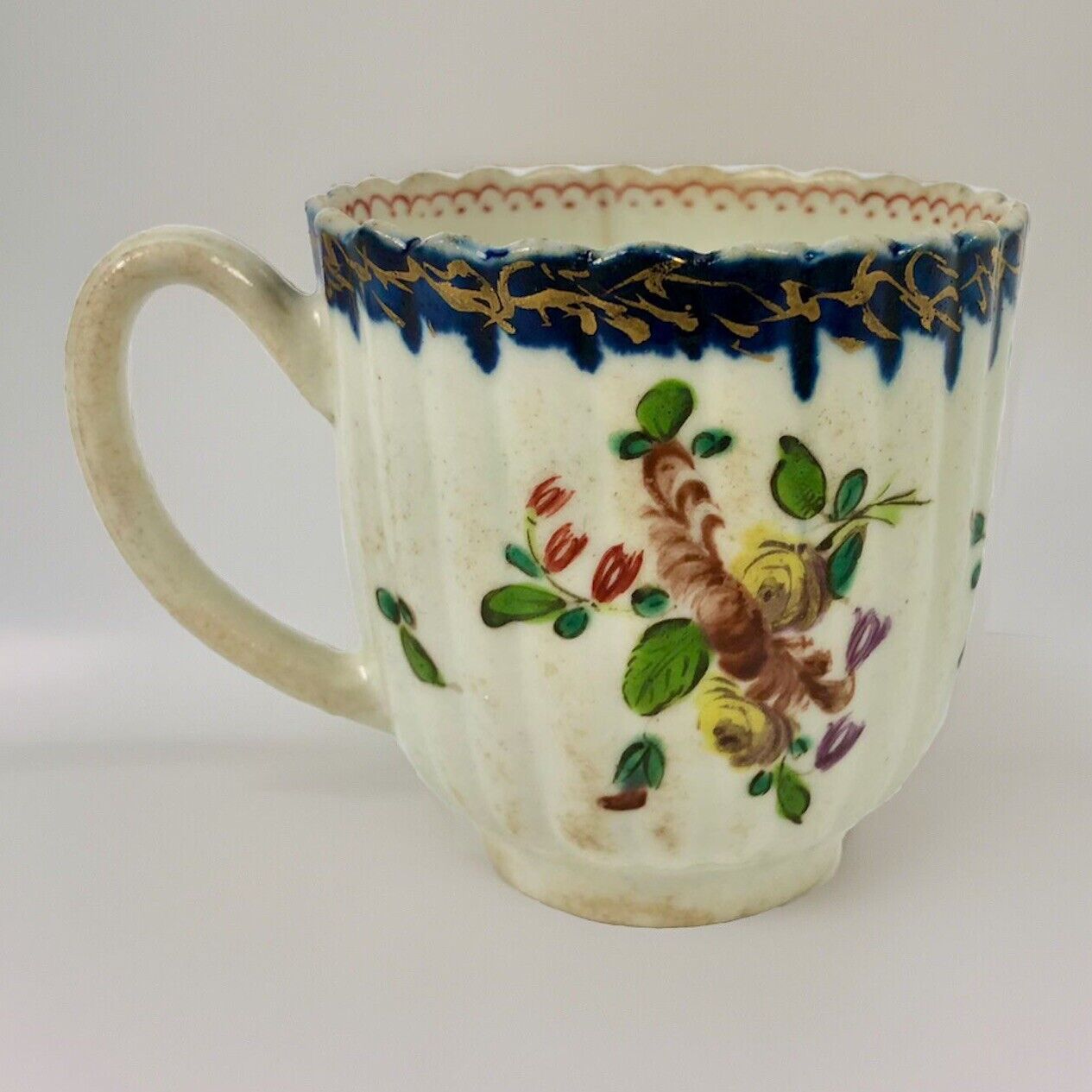 A Seth Pennington fluted coffee cup with blue and gilt border .1780-90