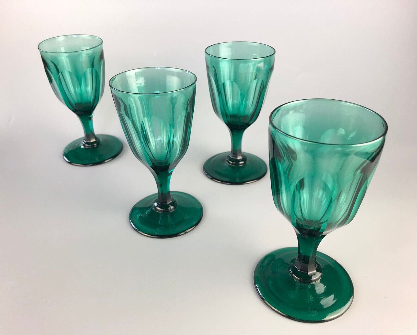 A set of four early Victorian (c1840) green glass slice-cut wine glasses