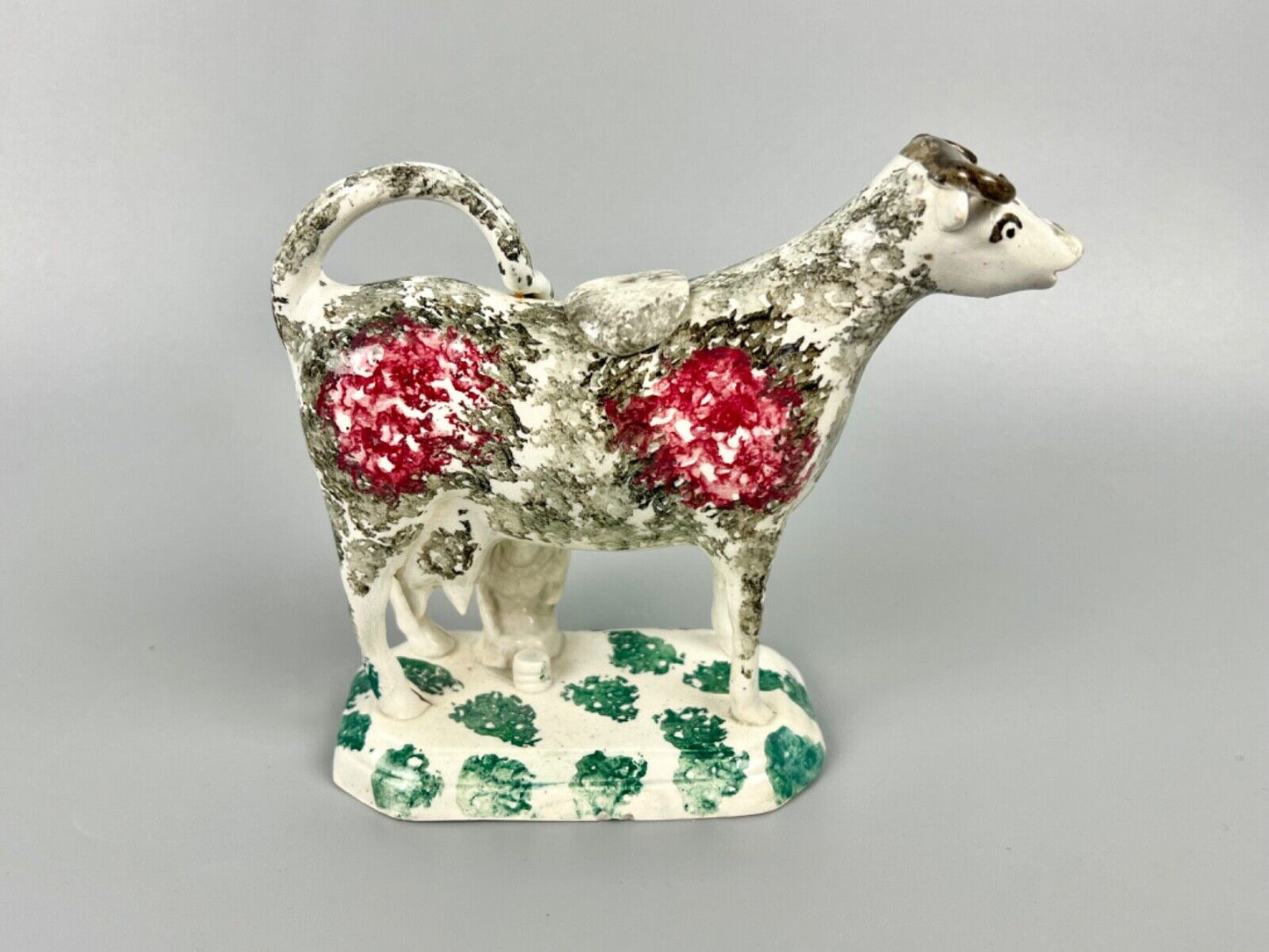 A c.1820 pottery cow and milkmaid creamer in crimson and black. Poss. Yorkshire