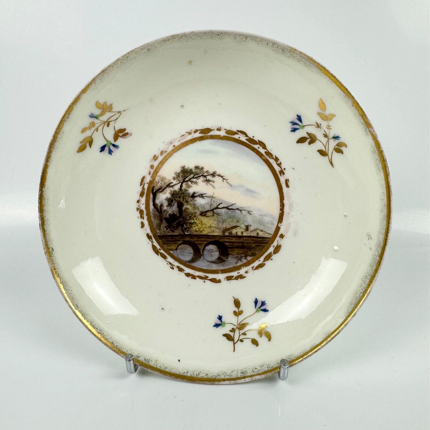 A Pinxton cup and saucer in pattern 174 with painted scenes by Billingsley c1810