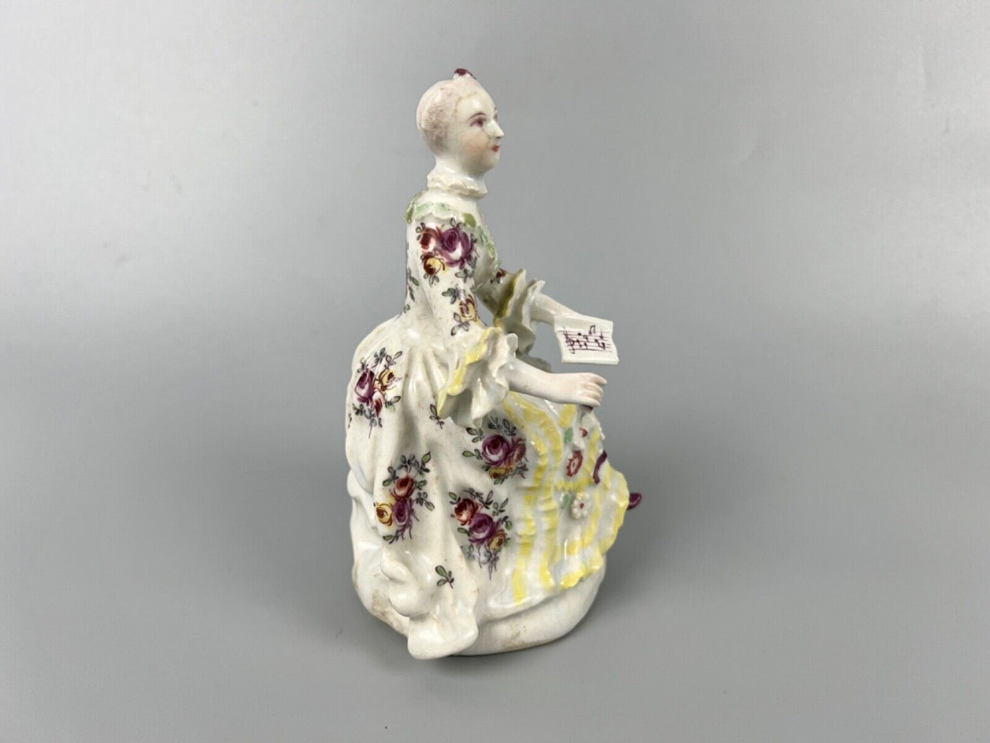 A Derby 'Pale Family' figure of 'Lady Seated Holding a Musical Score'. c1756-9