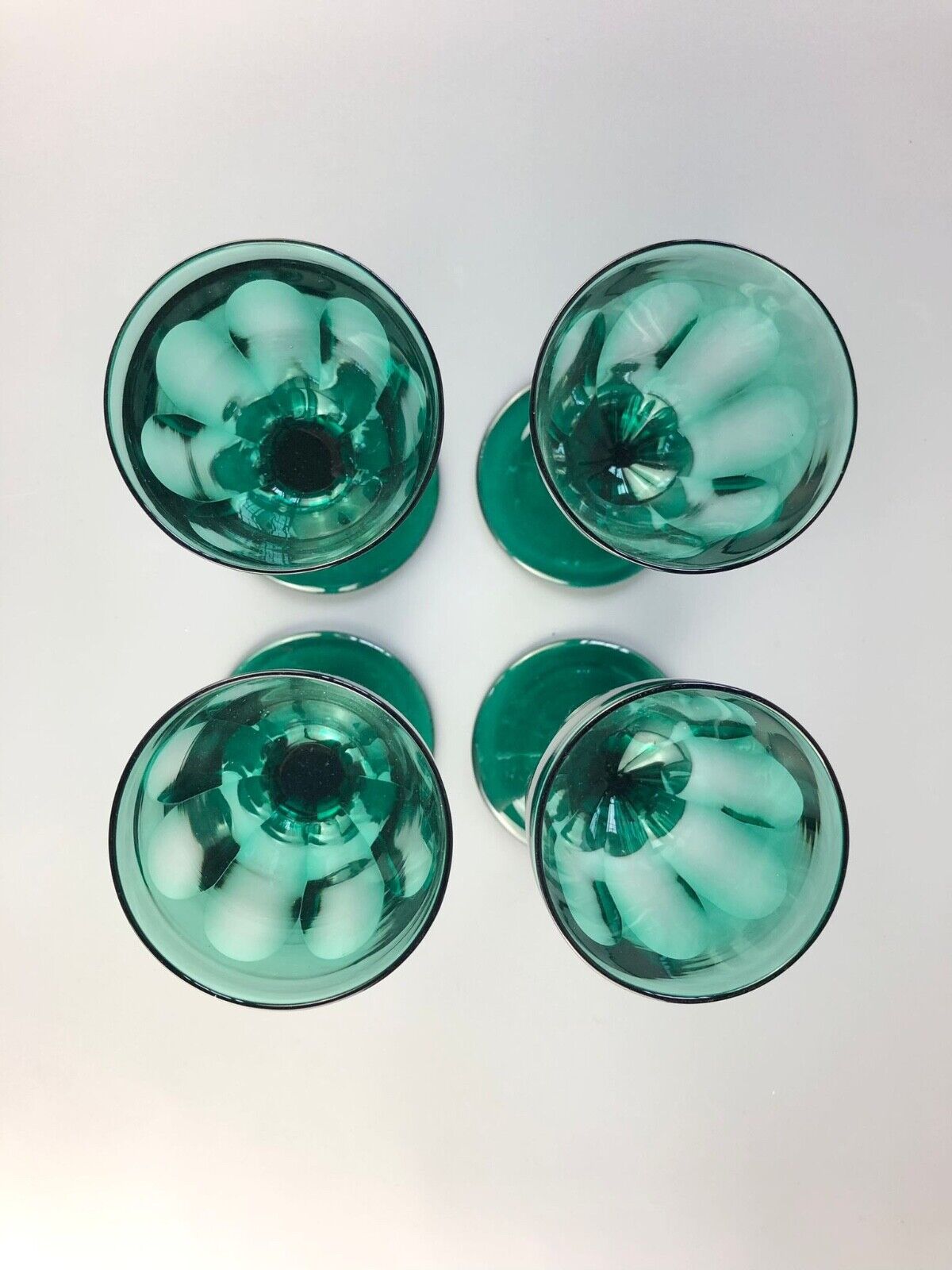 A set of four early Victorian (c1840) green glass slice-cut wine glasses