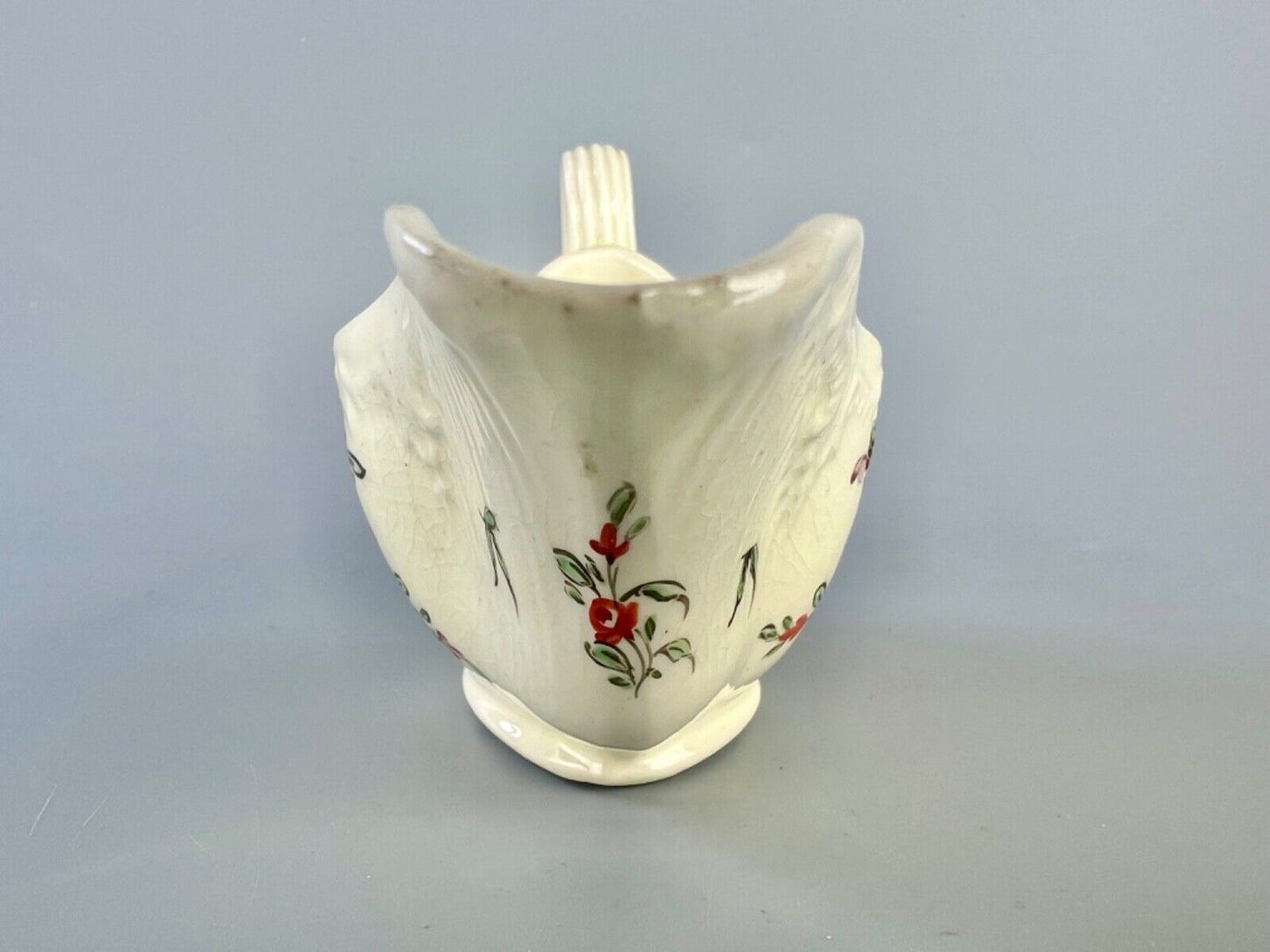 A c1775 creamware sauceboat painted with floral sprays. Probably Staffordshire.