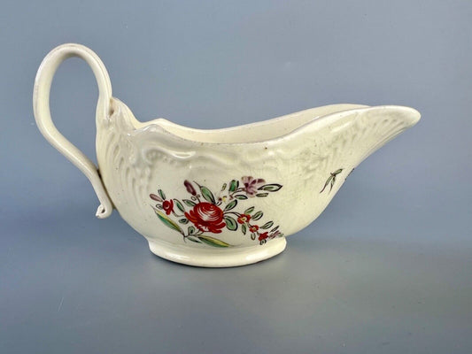 A c1775 creamware sauceboat painted with floral sprays. Probably Staffordshire.