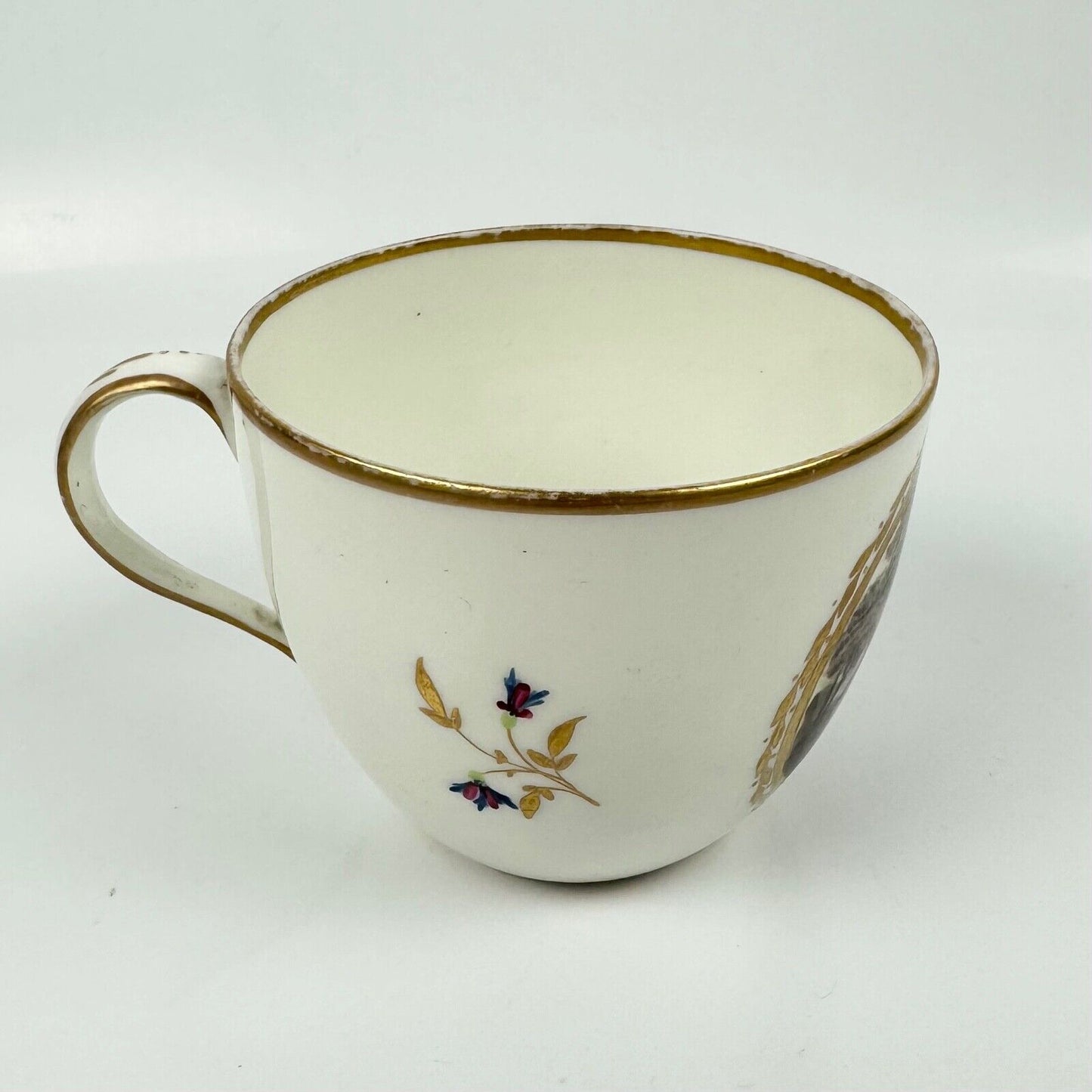 A Pinxton cup and saucer in pattern 174 with painted scenes by Billingsley c1810