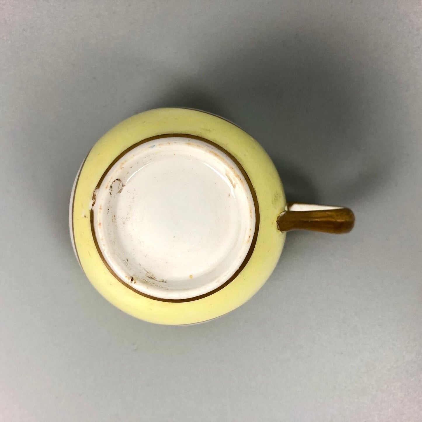 A Pinxton coffee cup and saucer in yellow ground and sepia landscapes. C.1796-9