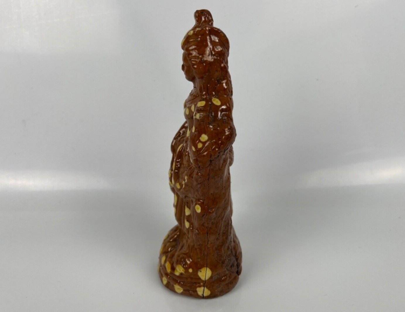 A cream dot decorated slipware figure of a woman on a treacle ground c1835
