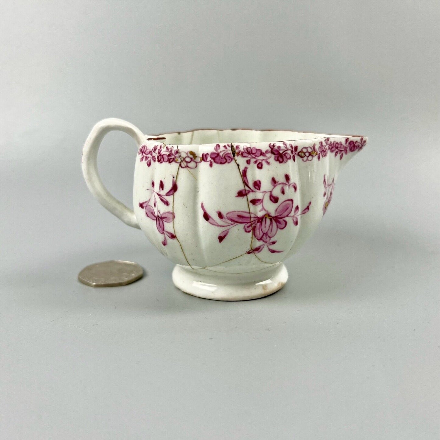 A rare early Derby peach-shaped creamer in 'Banded Hedge' pattern c.1765
