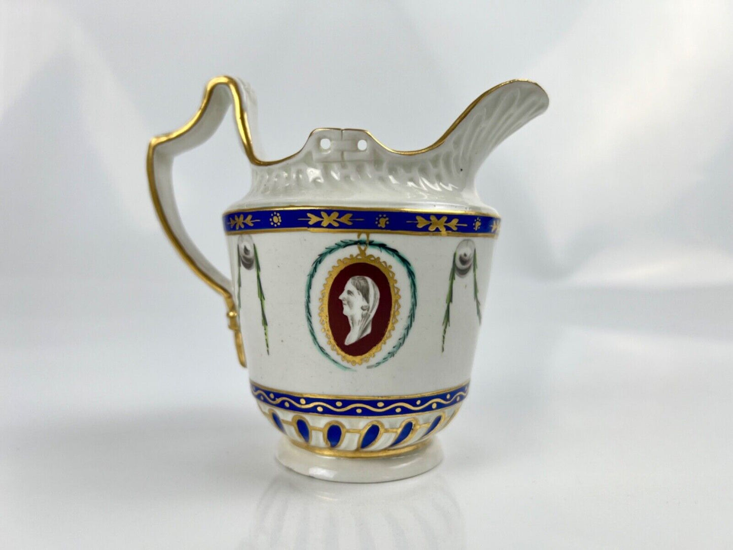 A Chelsea-Derby cabaret creamer of empire shape painted with mask heads c.1770