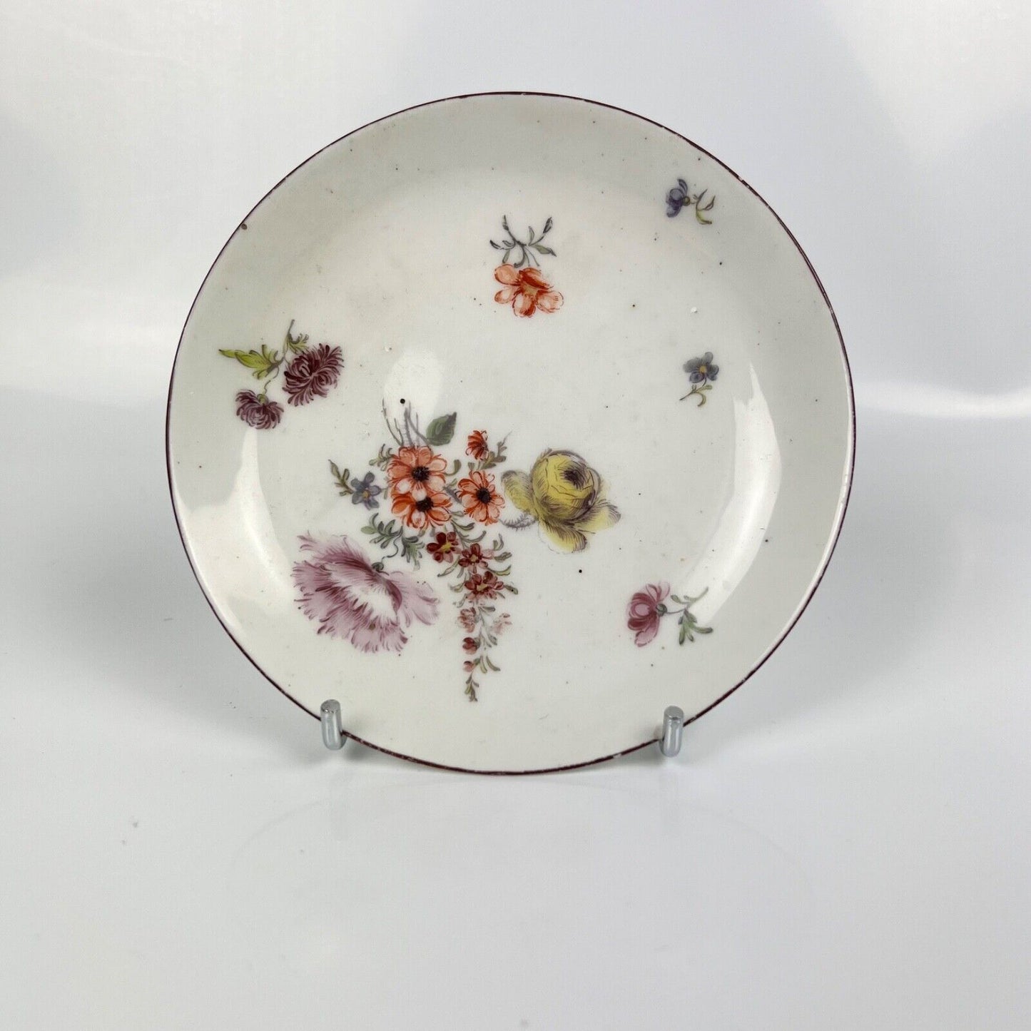 A A Chelsea floral-painted saucer with brown rim. c.1758