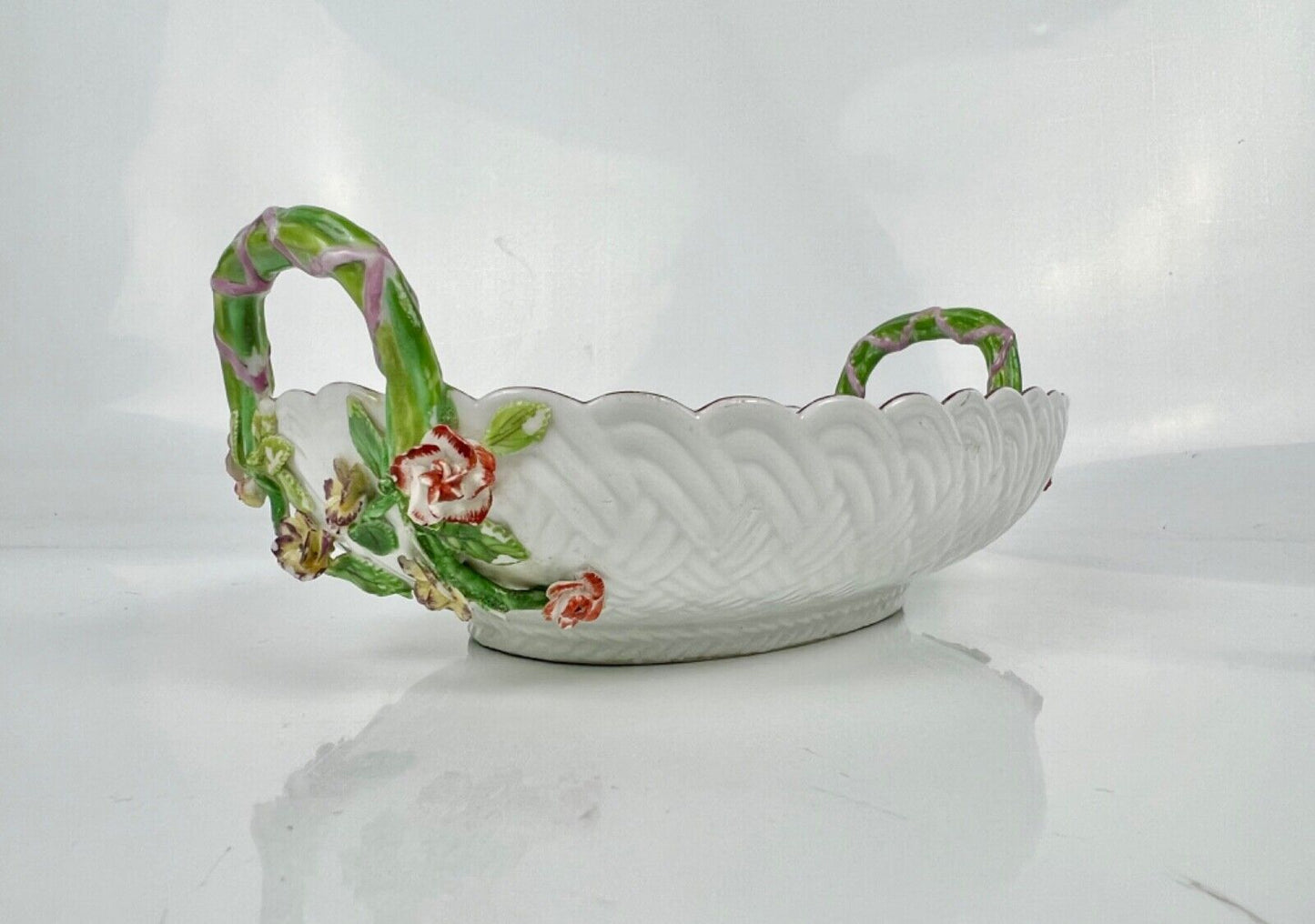 A good Chelsea basketweave moulded basket painted with bouquets. Rustic handles