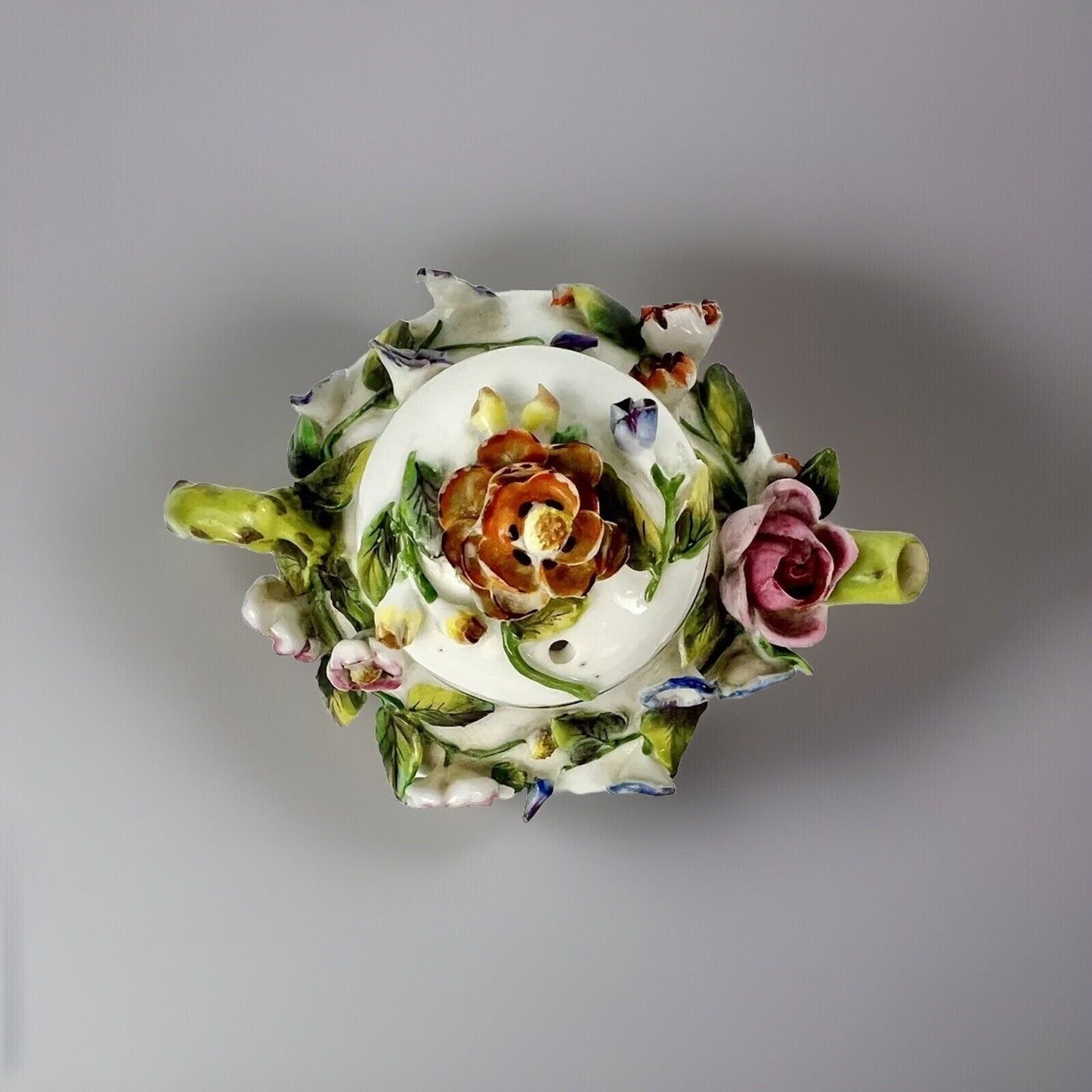 A Rockingham flower-encrusted squat globular teapot and cover. Puce mark 1831-7
